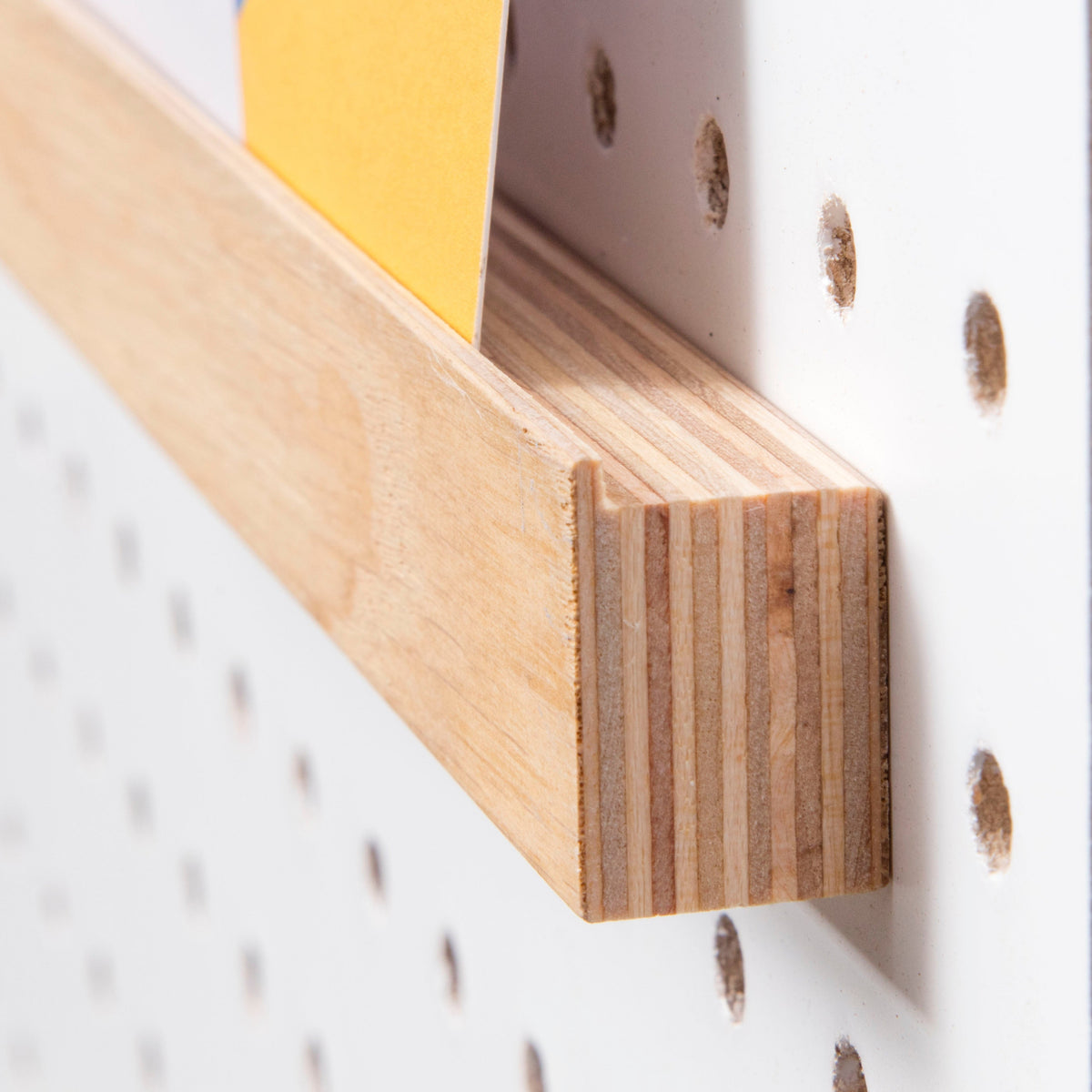 wooden pegboard picture shelf on white pegboard
