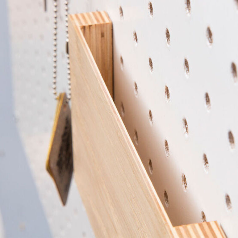 wooden pegboard letter holder on white display pegboard