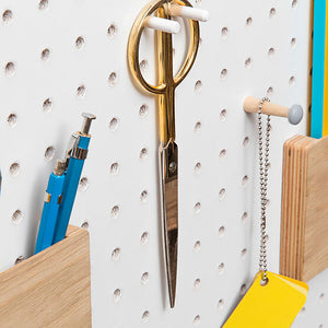 White pegboard with wooden pegboard accessories